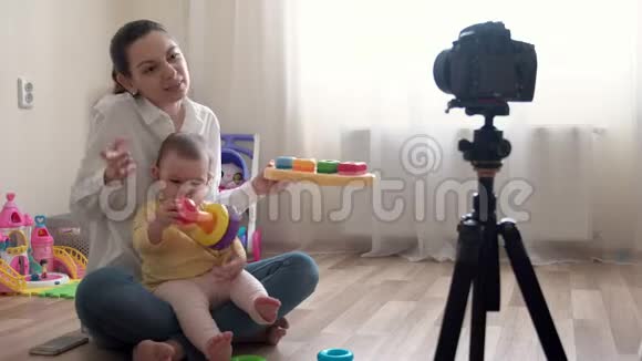 年轻的母亲带着小男孩在摄像机上录制视频并对家庭和童年进行录像视频的预览图