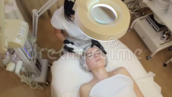 美容师让一个年轻女孩在水疗中心对面部进行超声波清洗视频的预览图