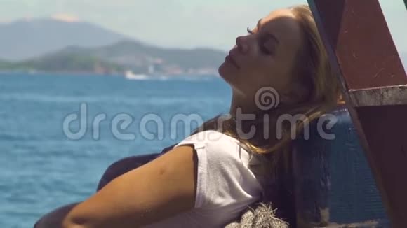 美丽的女人在海上的帆船上放松年轻女子在海上航行蓝色海洋视频的预览图