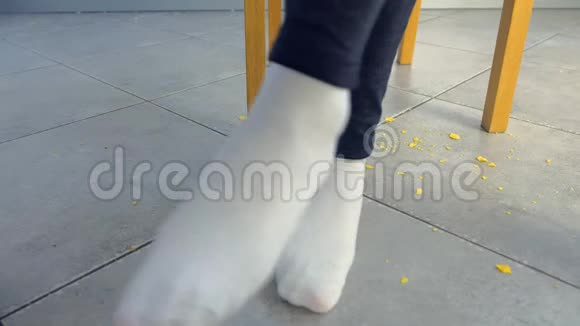 女人从桌子上站起来踩着桌子下面的面包屑摇着脚双脚特写视频的预览图
