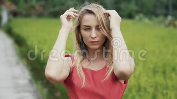 一个年轻美丽的女孩她的头发流动手上有纹身在绿色的田野上跳舞温柔而又性感视频的预览图