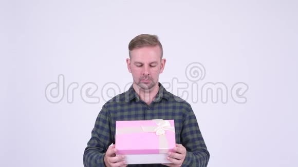 快乐的金发时髦男人打开礼物盒看上去很惊讶视频的预览图