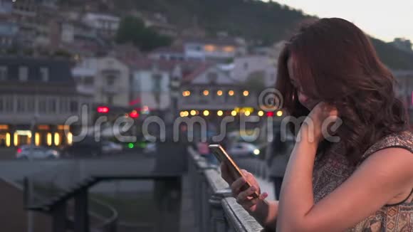 有魅力的女人在夜城街道上使用手机慢动作视频的预览图