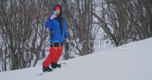 在滑雪坡滑雪时使用智能手机拍摄风景图片视频的预览图