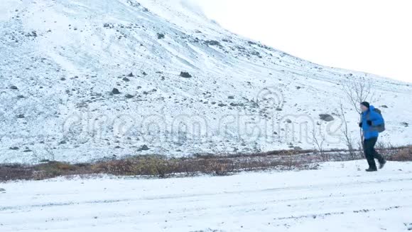 一个背着背包的人在下雪的路上旅行它沿着一个高脊视频的预览图