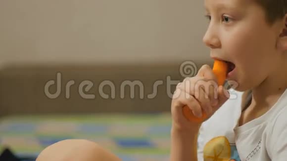 男孩在沙发上吃胡萝卜视频的预览图