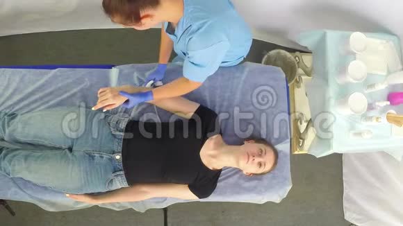 这位女美容师在病人懒散之前用保湿喷雾治疗病人的手部皮肤视频的预览图