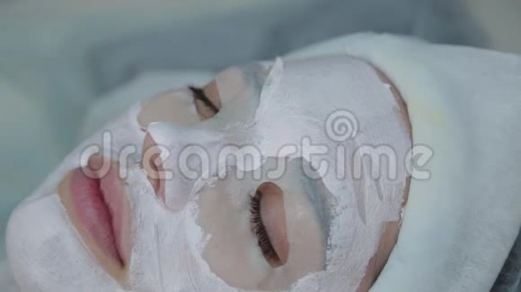 在一家美容院里美丽的女人戴着面具躺在床上视频的预览图