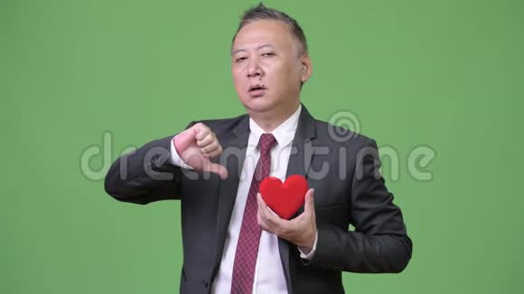 成熟的日本商人捧着红心准备情人节视频的预览图