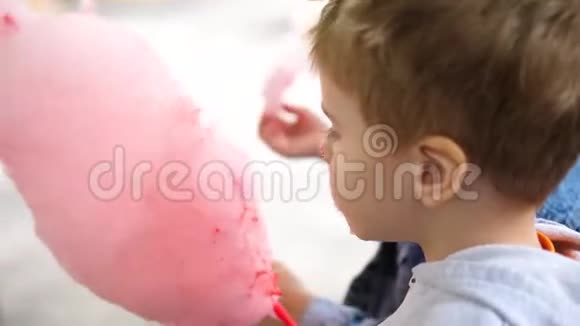 公园里的一个男孩在吃透气的棉花糖孩子生日视频的预览图