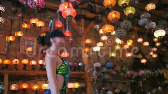 带VR眼镜的旅游妇女在传统灯具的纪念品商店购物视频的预览图