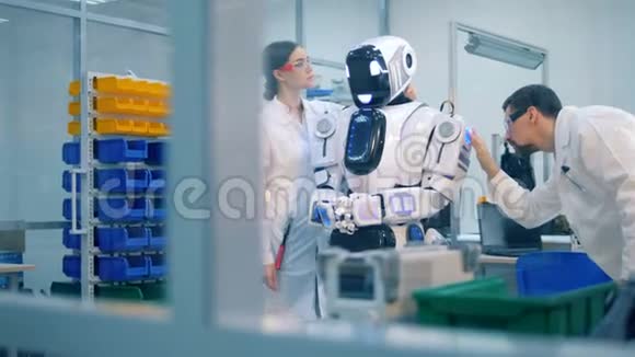 两名专业人员正在检查一个机器人人形机器人视频的预览图