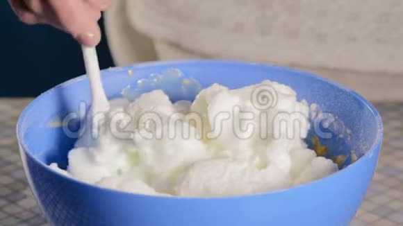 密切注意厨师在碗中加入奶油面团成分视频的预览图