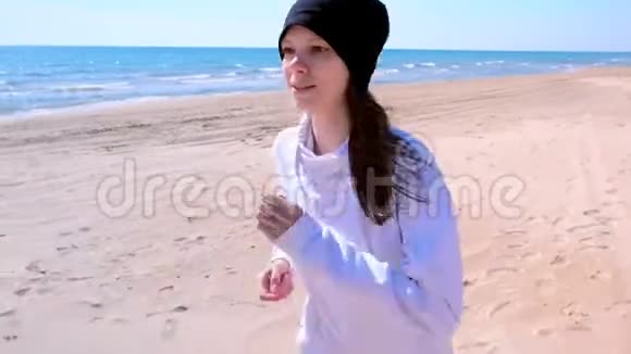 女孩在海边慢跑沙滩上慢跑户外运动视频的预览图