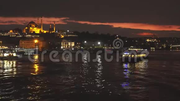 金色之角的旅游船在黄昏灯光的背景下伊斯坦布尔城市景观与Suleymaniye清真寺视频的预览图