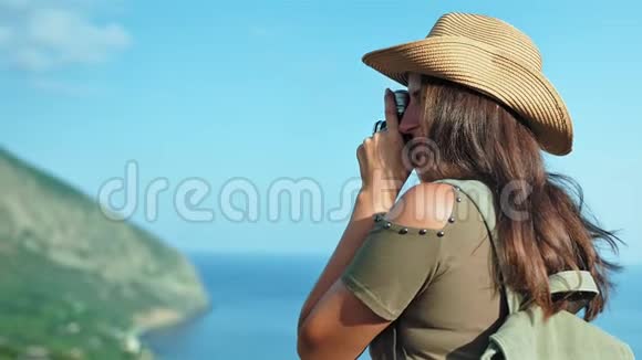 女摄影师在日落时用专业的老式摄像机拍摄海景视频的预览图