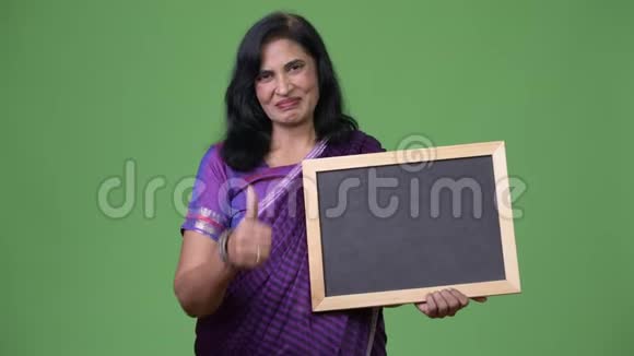 成熟快乐美丽的印度女人边笑边黑板边竖起大拇指视频的预览图