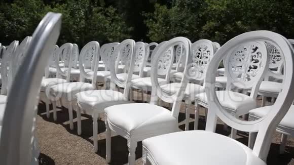 白色椅子和白色和红色鲜花的婚礼装饰靠近海边的花店视频的预览图