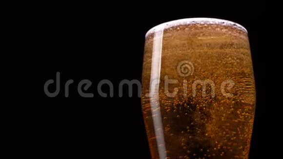 啤酒在玻璃中的黑色背景下泡起来视频的预览图