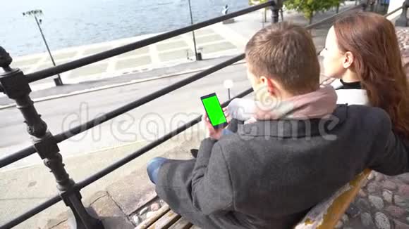 年轻夫妇坐在海滨的长凳上视频的预览图