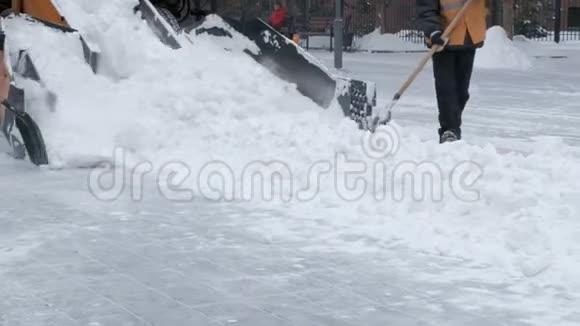 人们用铲子和拖拉机从雪地上清扫街道暴风雪过后打扫卫生市政城市道路养护赢视频的预览图