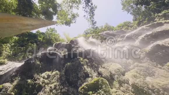 从底部的热带森林景观中水流在岩石悬崖上热带瀑布的流水视频的预览图