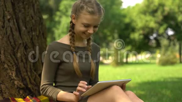女孩在平板电脑上搜索远程教育程序应用程序交互性视频的预览图