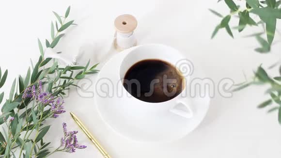 电影院咖啡杯婚礼花束绸带和白色桌子背景上的金笔桉树枝视频的预览图
