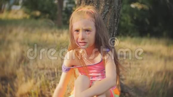 小女孩涂满了霍莉的颜色坐在树上哭泣视频的预览图