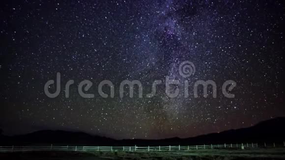 美丽的银河在山脉上移动在前景通过汽车前灯开着夜晚视频的预览图