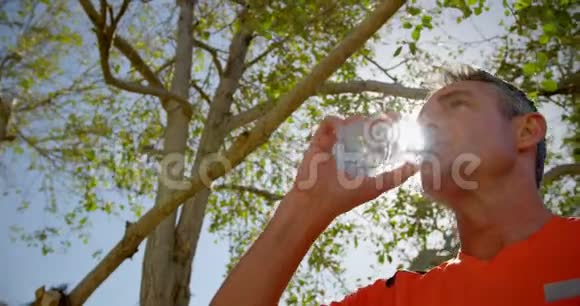 养老院花园男教练饮水低视角4k视频的预览图