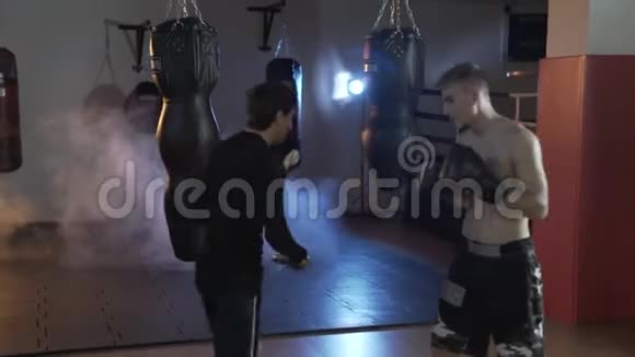 一个职业拳击手和他的教练在擂台上训练打击和反应的速度健身房里的那个人视频的预览图