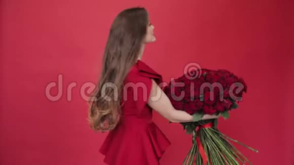 穿着红裙子手捧玫瑰的漂亮女人视频的预览图