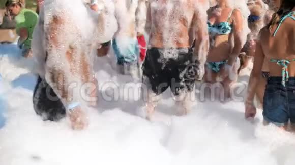 4k的焦点视频快乐人群覆盖肥皂泡沫跳舞在海滩迪斯科享受假期的年轻人视频的预览图