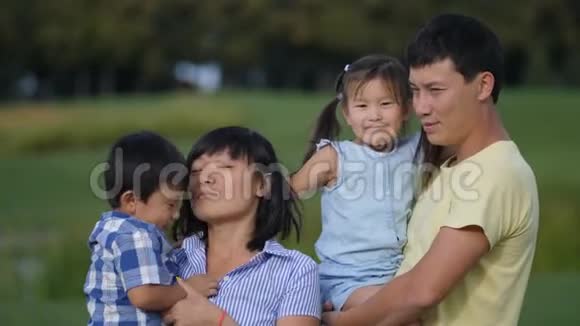 激动人心的亚洲四口之家在公园大笑视频的预览图