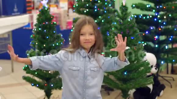 超市里的小可爱在圣诞树的背景下跳舞视频的预览图