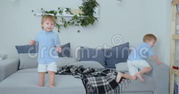 两个小男孩在沙发上跳着玩视频的预览图