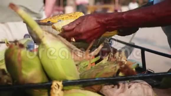 街头小贩烤一个甜玉米棒户外特写视频的预览图