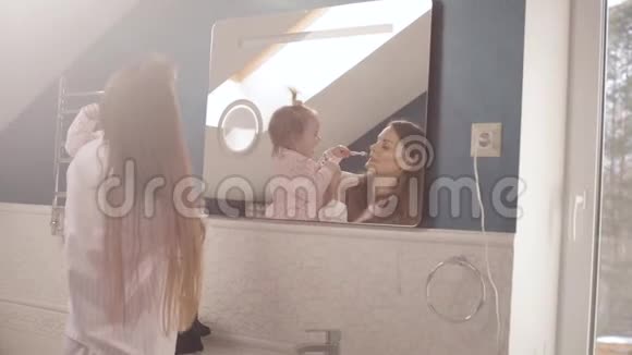 可爱的妈妈带着小家庭在浴室刷牙视频的预览图