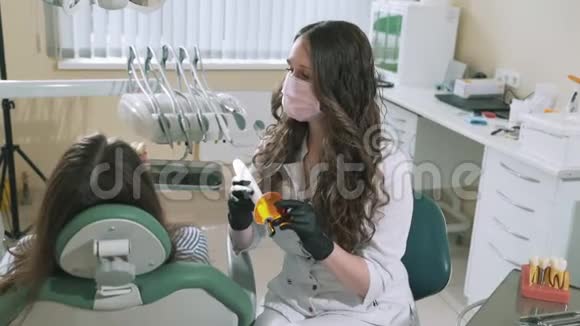 慢镜头拍摄一位女牙医使用光聚合物装置将填充材料固化在视频的预览图