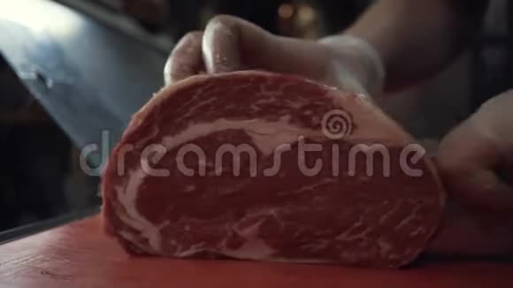有人的特写戴着防护手套整齐地把肉切在切割板上行动切割肉视频的预览图