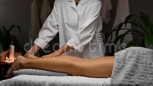 在水疗中心接受腿部按摩的女性按摩师做专业按摩视频的预览图