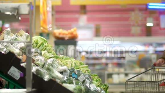 成熟的男性养老金领取者在超市的蔬菜部门选择西兰花甘蓝把蔬菜放进去视频的预览图