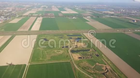 从飞机窗口看荷兰从飞机窗口看到绿色的田野和郁金香视频的预览图