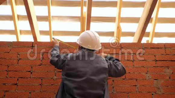 建筑工人测量建筑中的木梁视频的预览图