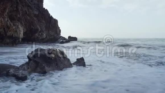 平静的海浪拍打着洞穴附近的岩石视频的预览图