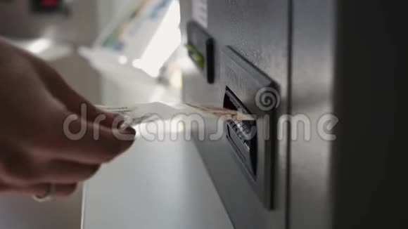 一个女人她的手在自动取款机上做钞票视频的预览图