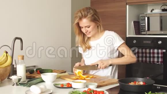 愉快的年轻女子准备晚餐在厨房概念烹饪视频的预览图