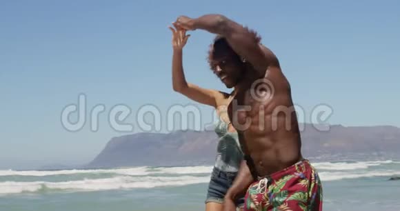 一对夫妇在阳光下在海滩上跳舞视频的预览图