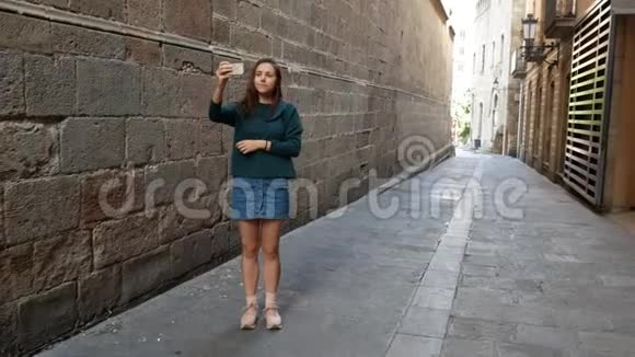 站在欧洲大街上拍一张照片的年轻女孩视频的预览图
